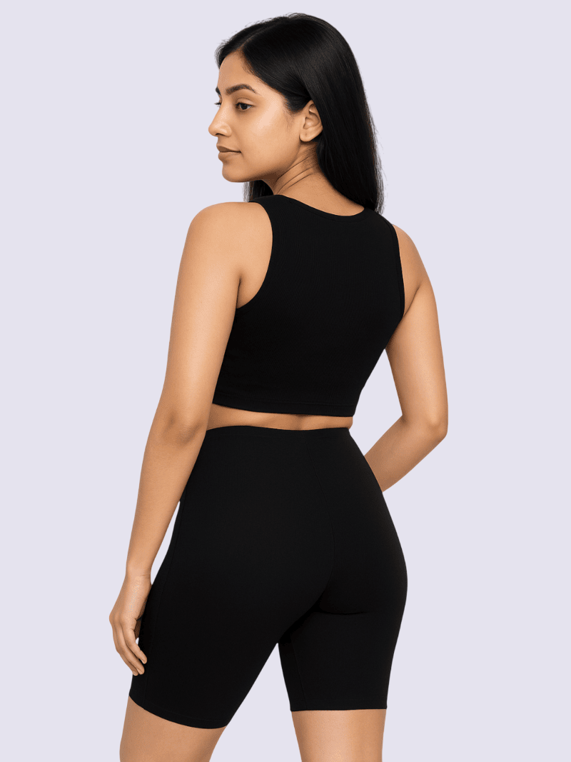 Woman wearing a black athletic outfit on a light gray background